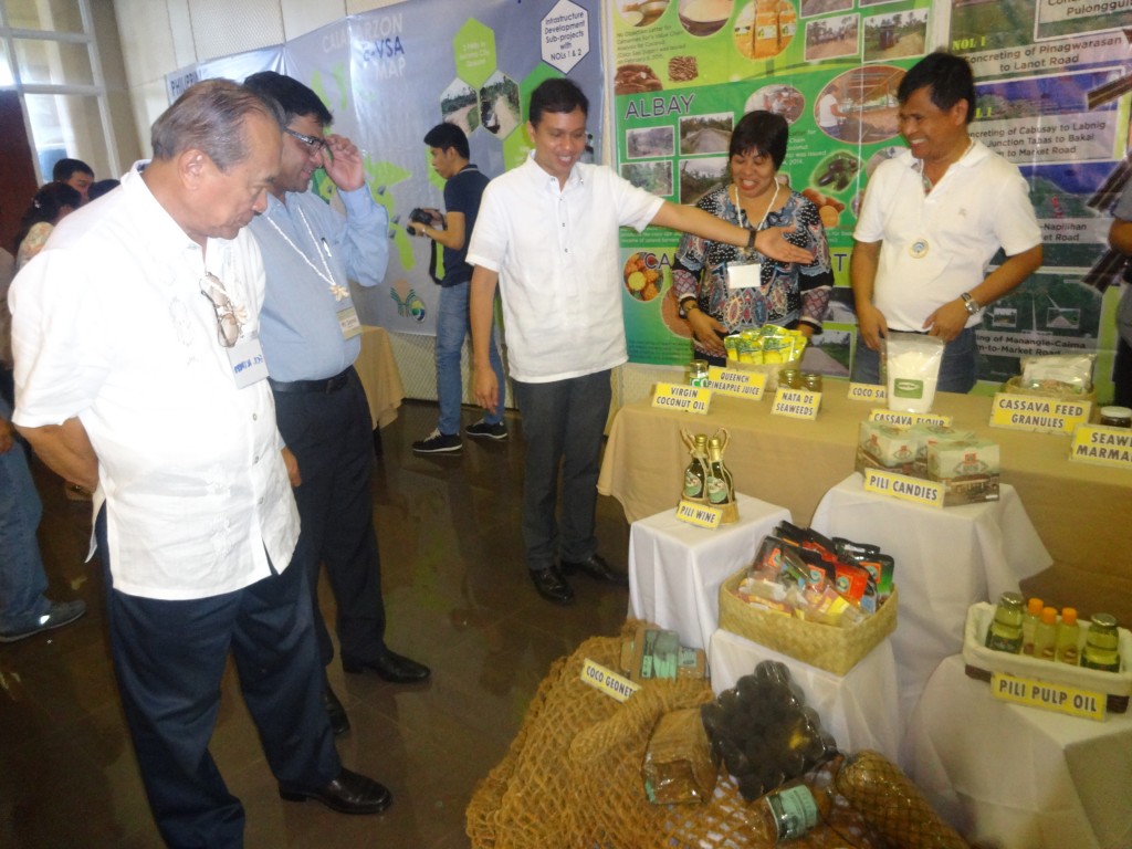  PRDP Project Support Office South Luzon Director Shandy M. Hubilla (3rd from left) shows the regional commodity products of Bicol to World Bank Project Team Leader Samik Sundar Das (in blue, 2nd from left) and Palawan Governor Jose Ch. Alvarez (in white, 1st from left). RPCO V I-REAP Component Head Adelina A. Losa and Camarines Norte Governor Edgardo A. Tallado look on. Coco geonets, pili pulp oil, pineapple juice, and cassava feed granules were among the region’s priority commodity products exhibited during the PRDP 1st Implementation Support Mission to South Luzon Cluster.  