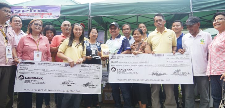 OFFICERS AND MEMBERS of the Tupi Coffee Growers Association, Inc. (TUCOGAI) received from DA Secretary Manny Pinol the first tranche of the budget for the P17.9-million Enhancement of Production and Marketing of Green Coffee Beans project. The checks are intended for the procurement of equipment and facilities that would jumpstart the enterprise project. Photo by Carl Aguillon/DA RPCO 12​